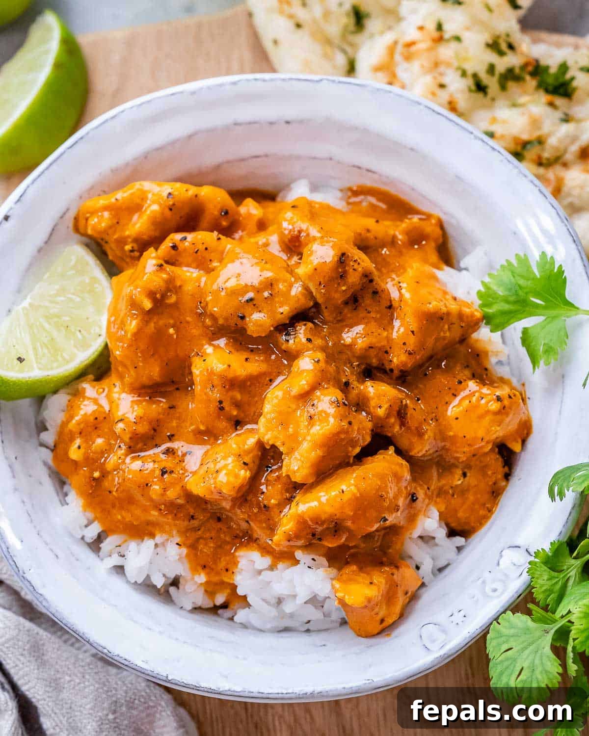 Creamy slow cooker chicken curry served over fluffy white rice in a bowl, garnished with fresh cilantro.