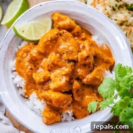 chicken curry over white rice in a bowl.