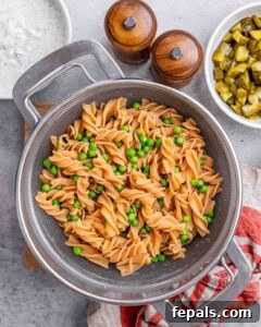 Cooked lentil rotini pasta in a colander, drained and sprinkled with fresh chopped dill.
