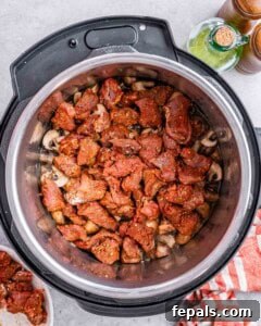Seasoned beef chunks inside the Instant Pot before broth is added.