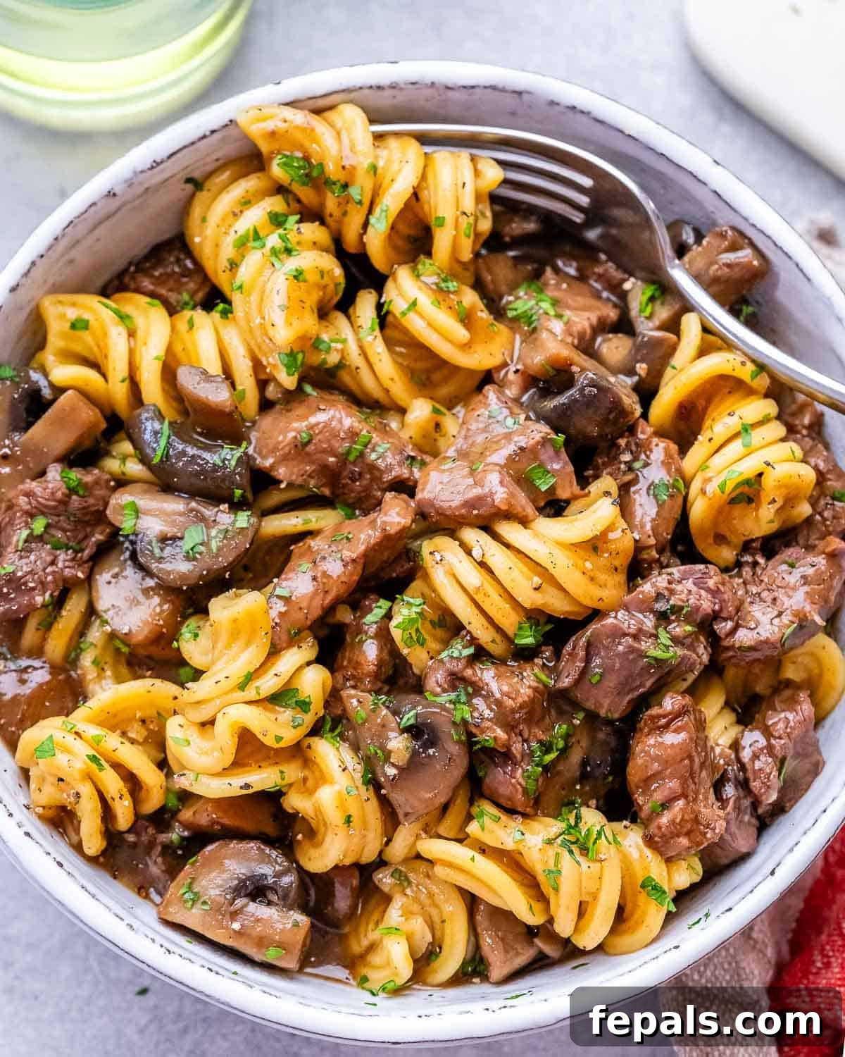 Quick and Creamy Instant Pot Beef Stroganoff 7 Top view of cooked beef stroganoff with tender beef, mushrooms, and pasta coated in a creamy sauce.