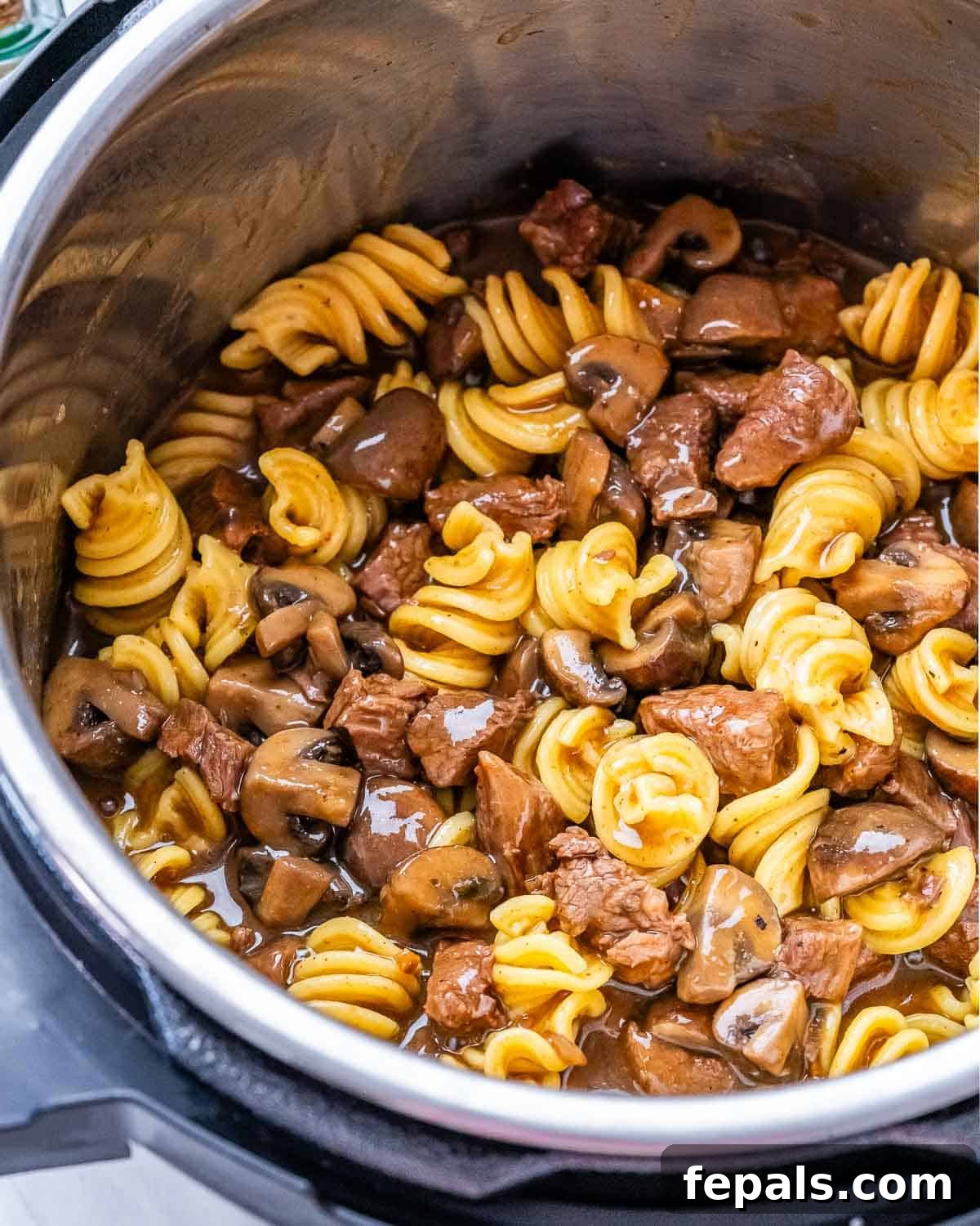 Quick and Creamy Instant Pot Beef Stroganoff 8 Pasta, beef, and mushrooms cooking together in the Instant Pot, almost ready to serve.