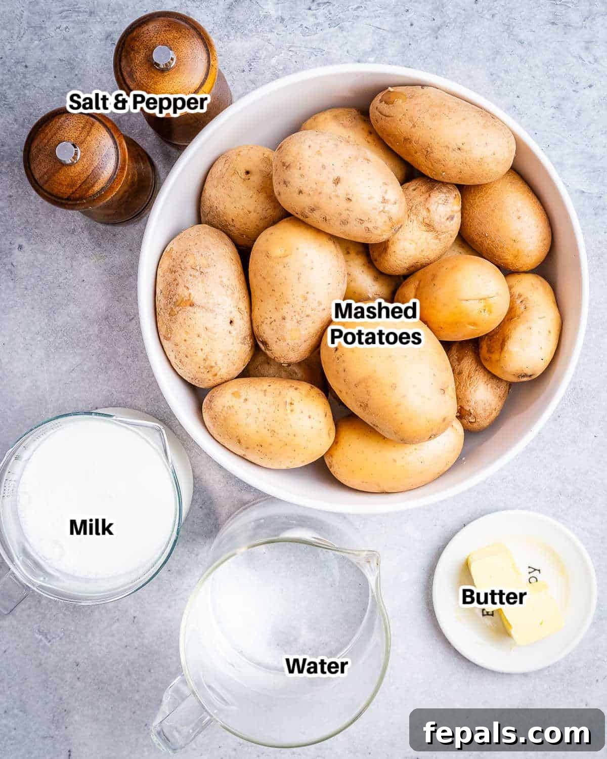 A collection of fresh ingredients laid out, including golden potatoes, a carton of milk, a stick of butter, salt, pepper, and fresh parsley, all ready to make Instant Pot mashed potatoes.