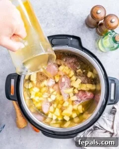 Chicken pieces, potatoes, and broth cooking together inside the Instant Pot.
