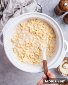 The mac and cheese cooking in the crockpot, showing its creamy consistency.