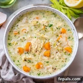 Avgolemono Soup: A Bowl of Bright Comfort 8 Top view of a pot of creamy Greek Avgolemono Soup filled with rice, carrots, and fresh herbs.