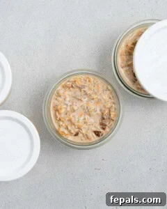 Dividing the prepared overnight oats mixture into glass mason jars for chilling.