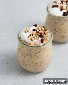 Finished carrot cake overnight oats in a jar, topped with additional ingredients, ready to eat.