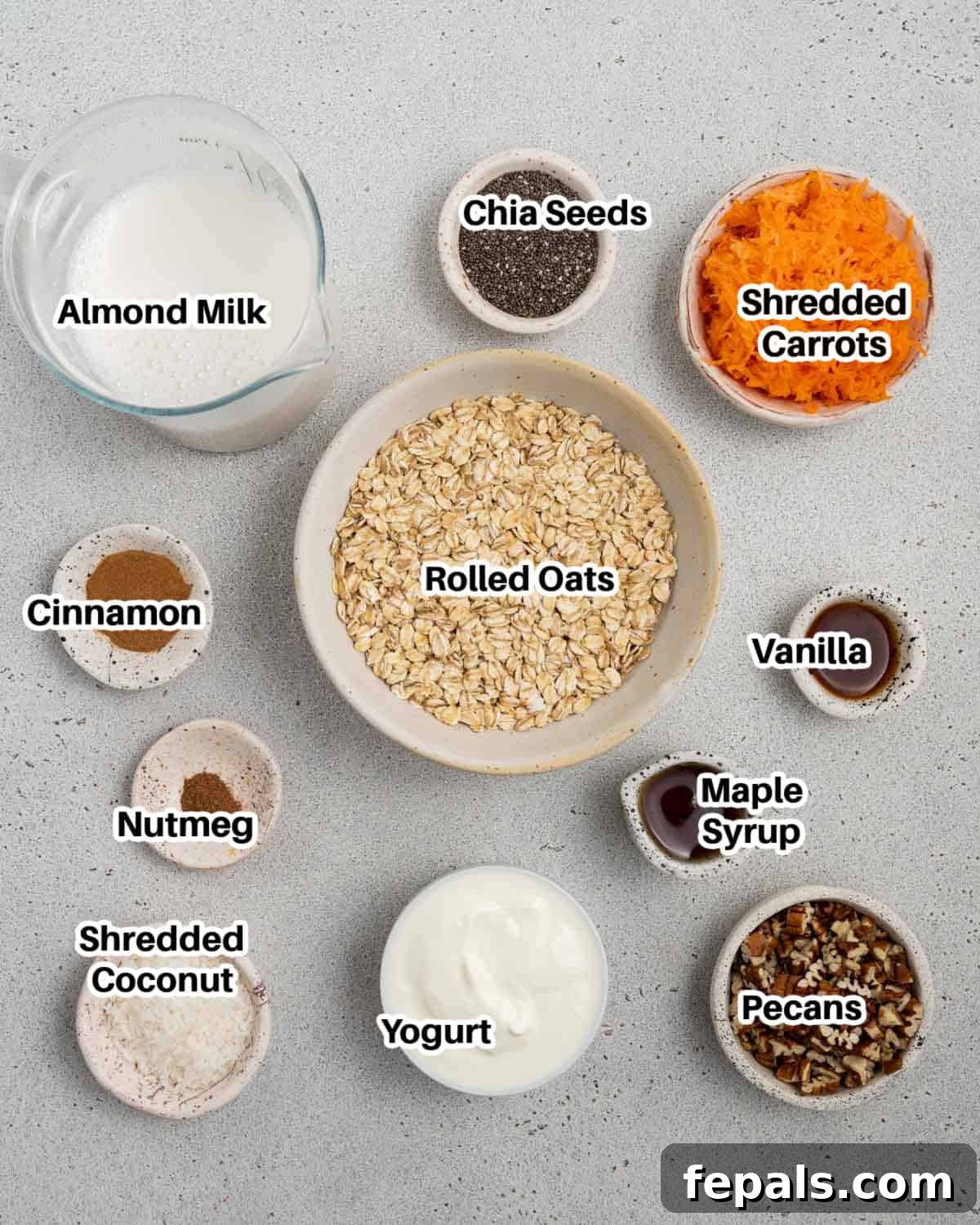 Spiced Carrot Cake Overnight Oats 3 A flat lay image showing all the fresh ingredients needed to make carrot cake overnight oats, including oats, carrots, yogurt, and spices.