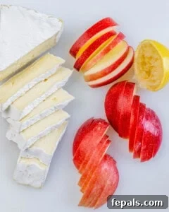 sliced apple and brie on a cutting board.