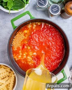 Adding tomatoes and broth to the pot