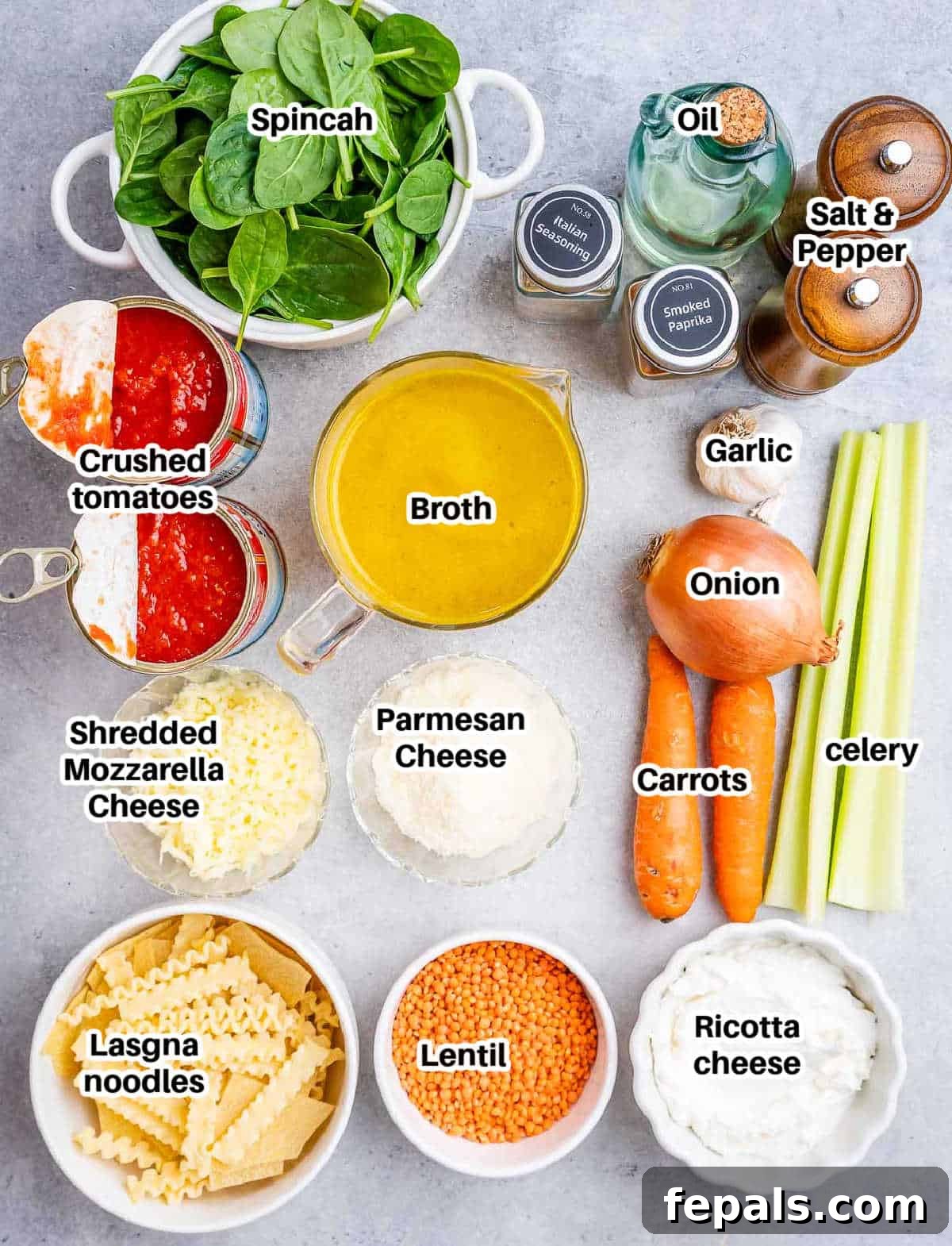 A flat lay of vegetarian lasagna soup ingredients including vegetables, spices, lentils, tomatoes, and cheese.