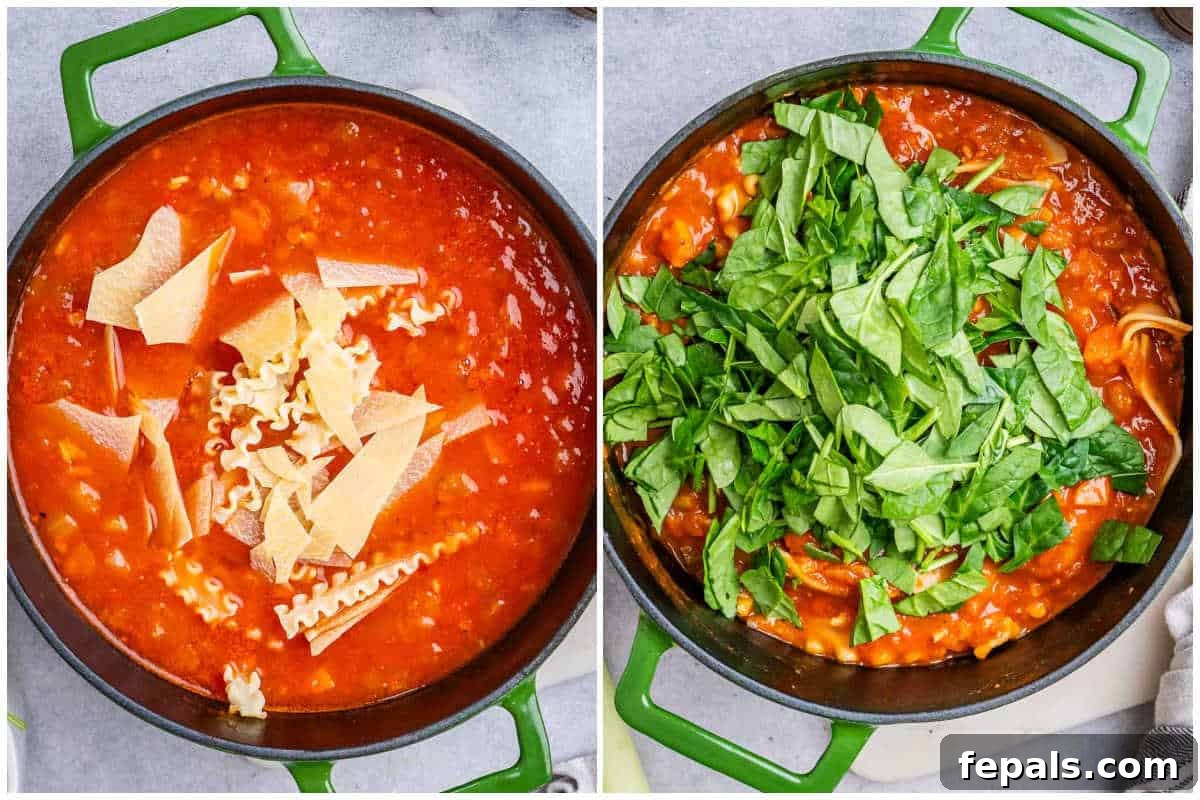 Process shot of adding broken lasagna noodles and fresh spinach to the simmering soup.