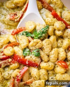 Velvety Pesto Gnocchi 14 Pesto gnocchi in a pan with a spoon.