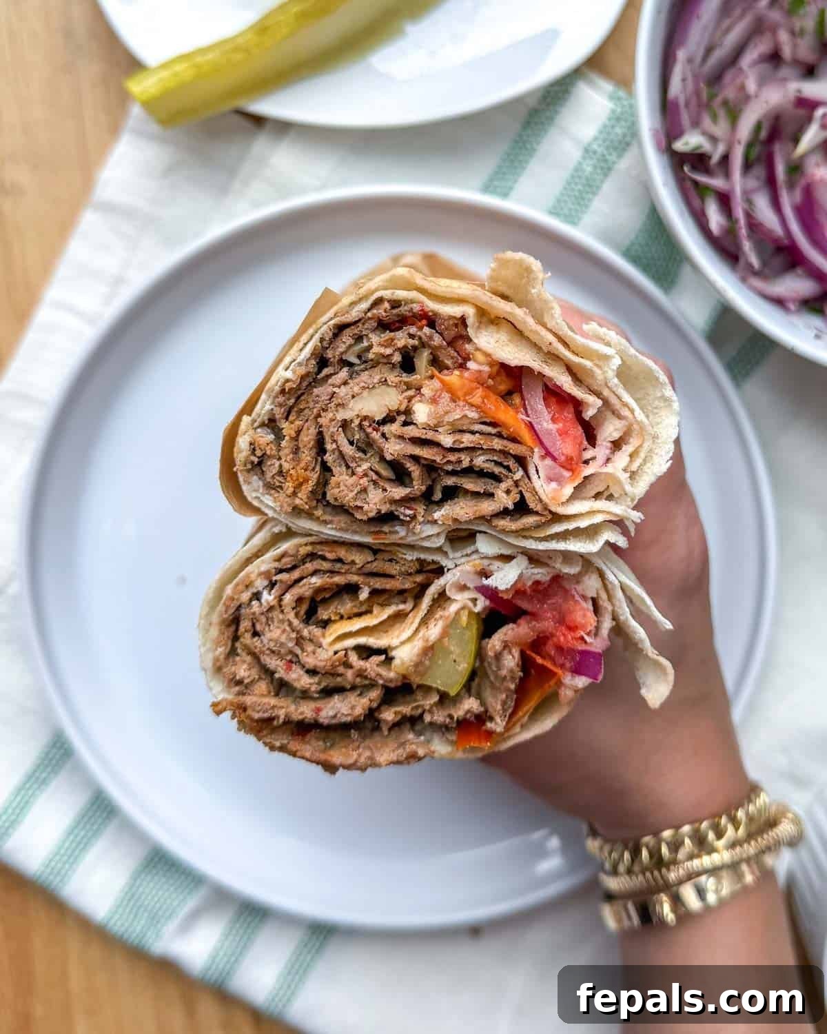 A doner kebab sandwich, generously filled with meat and fresh vegetables, cut in half to showcase its delicious layers.