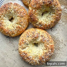 Freshly baked almond flour bagels arranged on a sheet pan, generously topped with savory everything bagel seasoning, highlighting their rustic charm and delicious crunch.