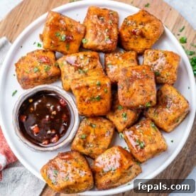 Top view salmon bites on a plate with a small bowl of sauce