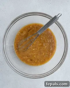 whisked mashed banana, oil, and eggs in a bowl.