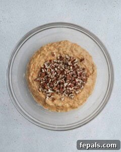 Chopped pecans added over muffin batter.