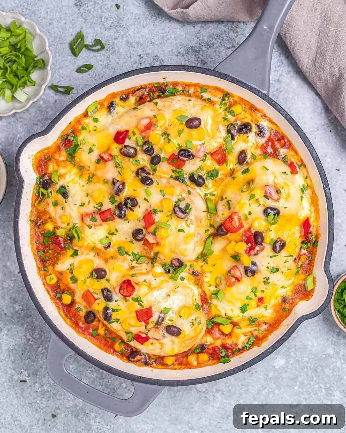 Sizzling Santa Fe Chicken Skillet with golden chicken breasts, vibrant corn, and roasted peppers, all topped with melted cheese.