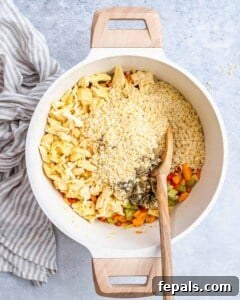 Adding shredded cooked chicken, dried thyme, salt, pepper, and stelline pastina to the sautéed vegetables in the pot.
