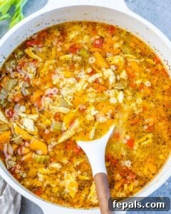 Chicken pastina soup simmering in a pot, with pasta cooking to al dente.