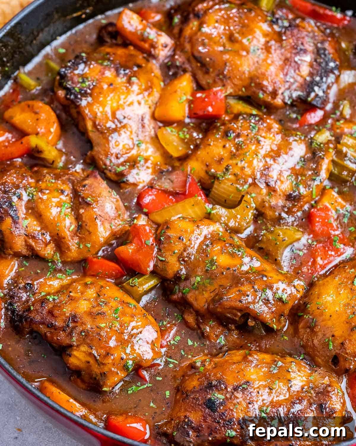 Classic Caribbean Brown Stew Chicken 6 A close-up view of a rich, bubbling pot of Brown Stew Chicken, showcasing its tender chicken pieces and vibrant vegetables.