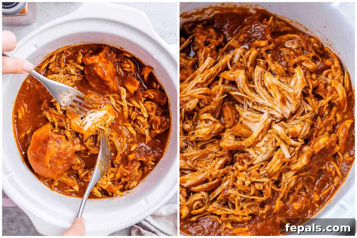 Effortless Slow Cooker BBQ Pulled Chicken 6 Cooked BBQ chicken being shredded directly in the crockpot with two forks, surrounded by rich sauce, ready to be served.