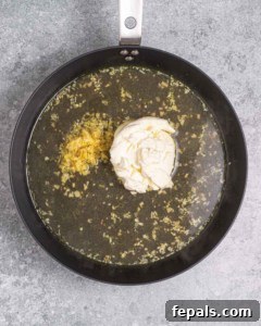 broth, lemon juice, and cream cheese added to the pan.