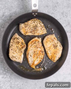 seared chicken breast in a black skillet.