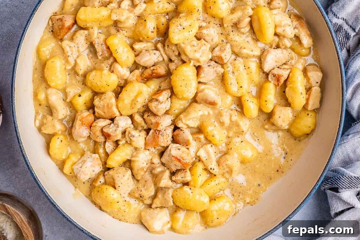 Pillowy Gnocchi Carbonara 7 Close-up of creamy chicken and gnocchi served in a rustic skillet, garnished and ready to eat.
