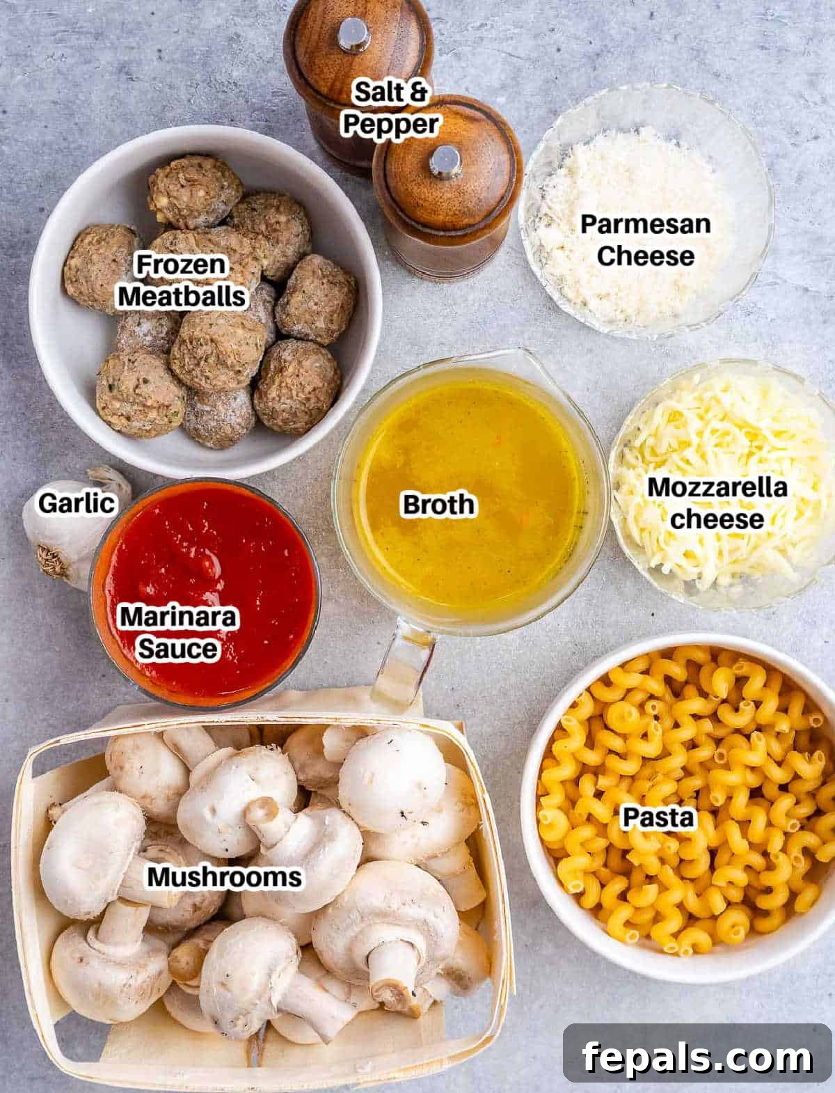 Effortless Meatball Bake 3 A flat lay of ingredients for dump-and-bake meatball pasta, including pasta, mushrooms, marinara, broth, garlic, meatballs, and cheeses.