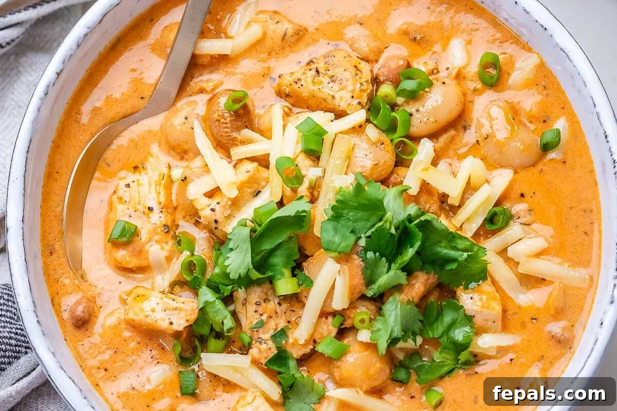 A white bowl of creamy crack chicken chili on a marble board, ready to be enjoyed.