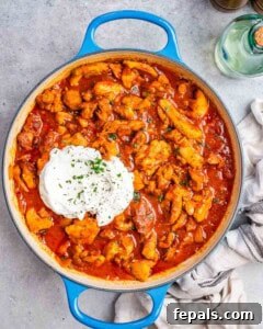 Adding full-fat yogurt to the cooled chicken paprikash sauce for a creamy finish.