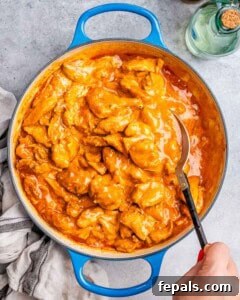 Garnishing finished Chicken Paprikash with fresh parsley before serving.