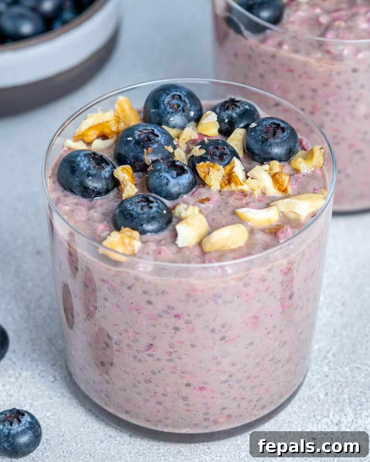 Easy Blueberry Overnight Oats 2 A cup with creamy blueberry overnight oats, generously topped with fresh berries and crunchy nuts, ready to enjoy.