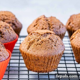 A tempting side shot of a single gingerbread muffin, its warm spices and festive charm evident, resting on a wire rack.