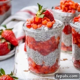 Side view of a glass jar filled with luscious strawberry chia pudding, beautifully topped with fresh, sliced strawberries for a burst of flavor and color.