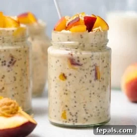 A side shot of a jar containing delicious peaches and cream overnight oats, beautifully topped with freshly chopped peaches, highlighting its sweet and fruity appeal.