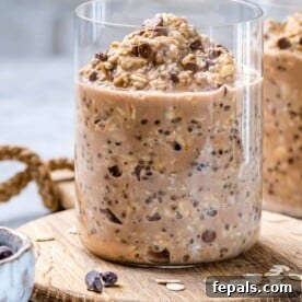 A beautifully presented jar of cookie dough overnight oats resting on a rustic wooden surface, highlighting the indulgent texture and appealing presentation.