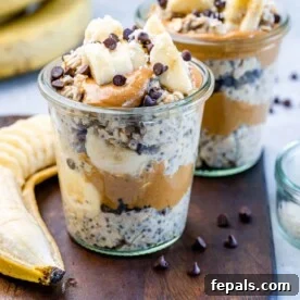 A side shot of a jar filled with creamy Chunky Monkey overnight oats, generously topped with fresh sliced bananas and indulgent chocolate chips.