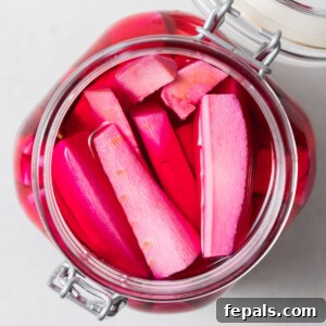 A jar of finished, perfectly pickled pink turnips, ready to be stored in the refrigerator and enjoyed.
