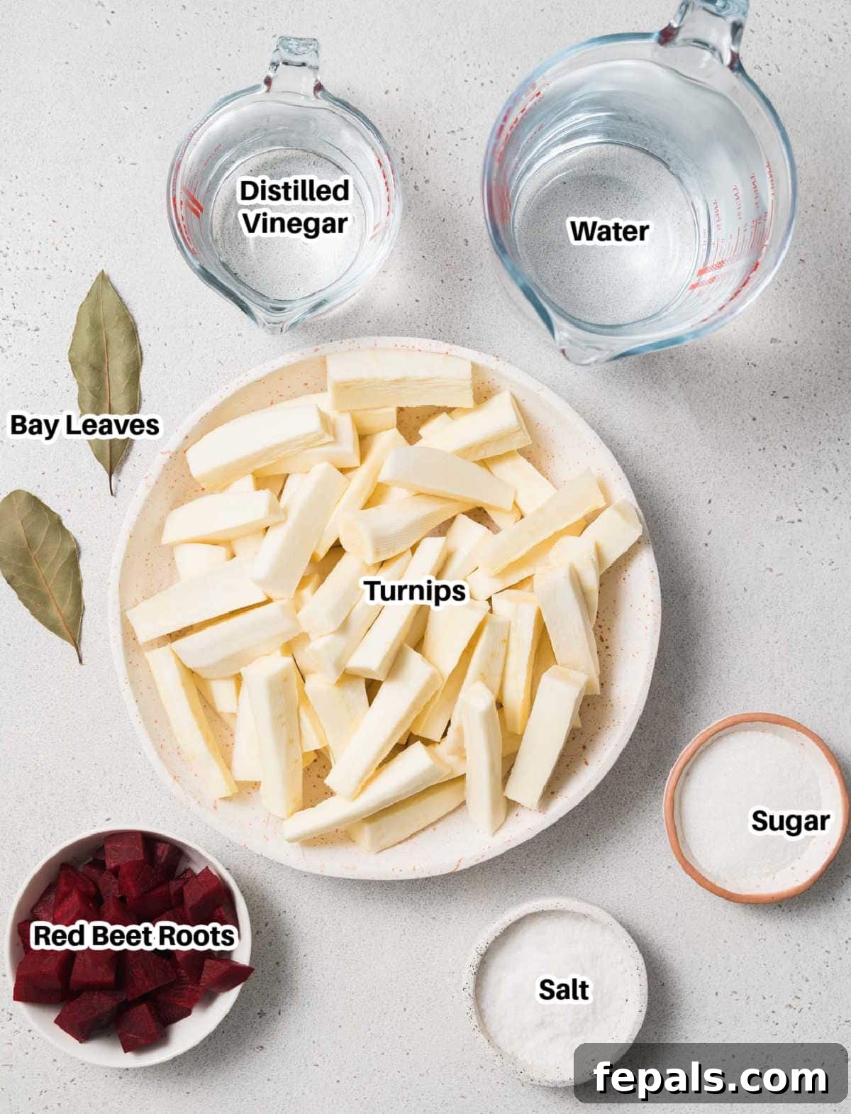 A collection of fresh ingredients laid out on a table, including turnips, beets, vinegar, salt, and sugar, prepared for making pickled turnips.