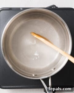 Water, sugar, salt, and vinegar are combined in a pan and boiled for a few minutes to create the pickling brine.