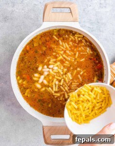 Beans and pasta added to the simmering soup.