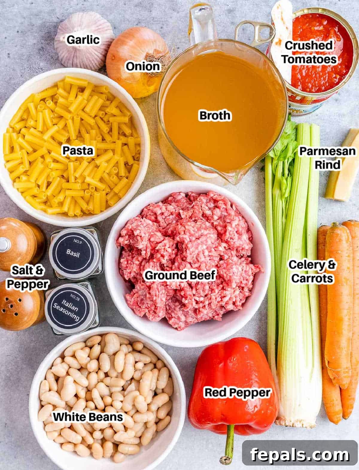 A flat lay image showing fresh ingredients for pasta fagioli including ground beef, diced vegetables, crushed tomatoes, and dried herbs.