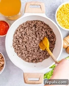 Ground beef browning in a Dutch oven.