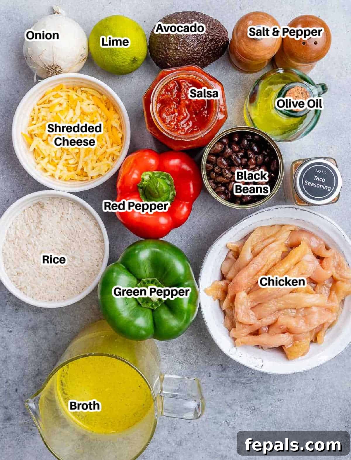All the fresh ingredients laid out to make chicken fajita casserole: rice, salsa, black beans, chicken broth, bell peppers, onion, chicken breast, olive oil, taco seasoning, salt, cheese, avocado, and lime.