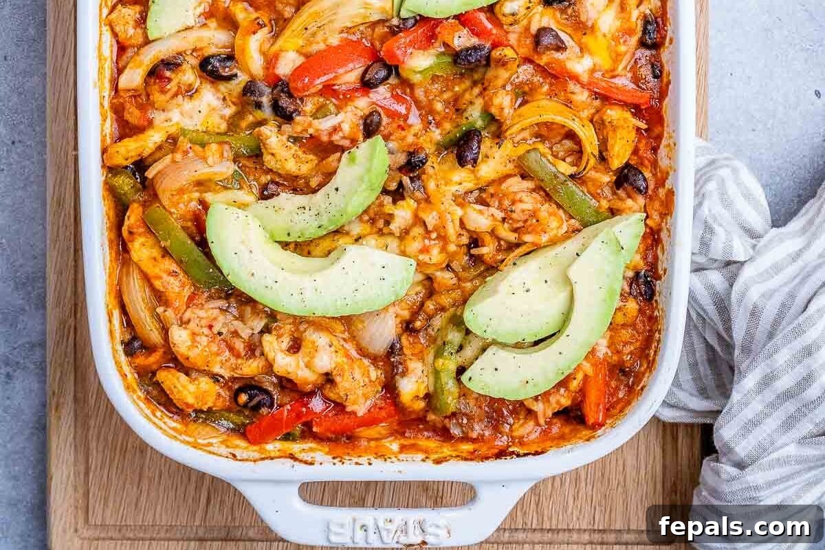 A vibrant chicken fajita casserole in a baking dish, beautifully topped with fresh sliced avocado, showcasing its delicious appeal.