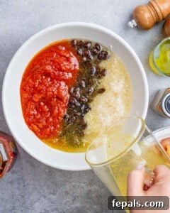 Process shot: Mixing rinsed jasmine rice with salsa, black beans, chicken broth, and salt in a bowl, before transferring to a baking dish.